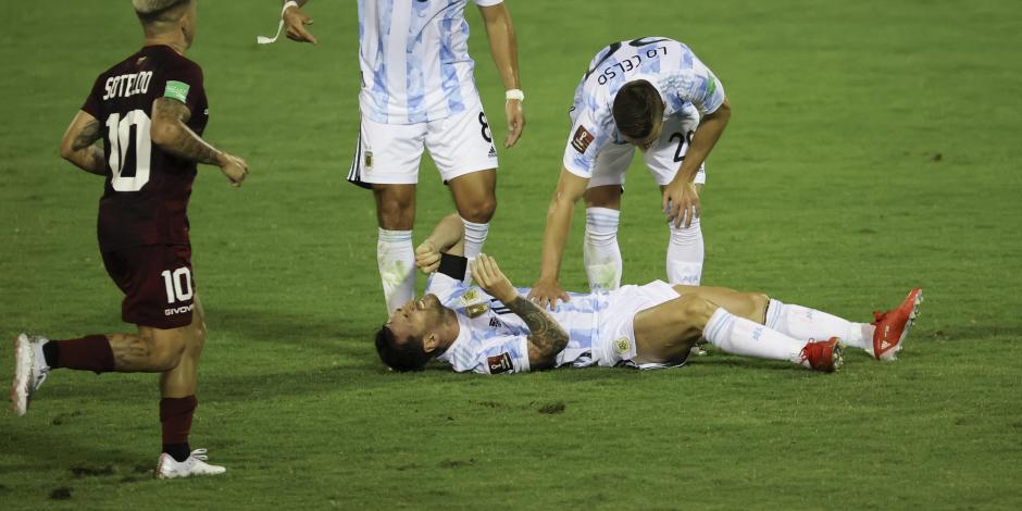 Lionel Messi se duele en el césped durante el partido entre Venezuela y Argentina, después de la dura patada que le dio Adrián Martínez.