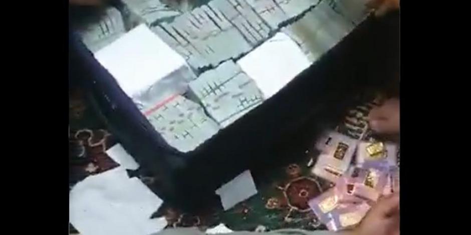 Maleta con fajos de billetes y barras de oro halladas por los talibanes.