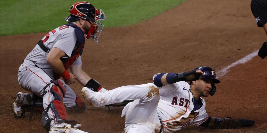 Yuli Gurriel, de Astros, anota una carrera ante el receptor de Red Sox, Kevin Plawecki, en el Juego 1 de la Serie de Campeonato de la Liga Americana de la MLB.