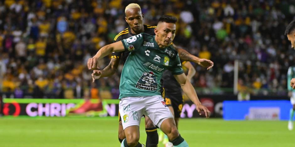 Ángel Mena retiene el balón ante la presión de Luis Quiñones, en la semifinal de vuelta entre León y Tigres.