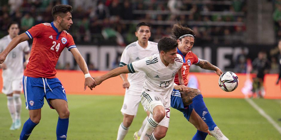 Alfonso González pelea por el balón ante dos jugadores durante el duelo amistoso entre México y Chile.