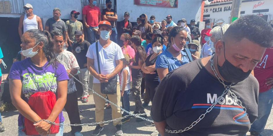 Los migrantes protestaron con cadenas amarradas en el cuello.