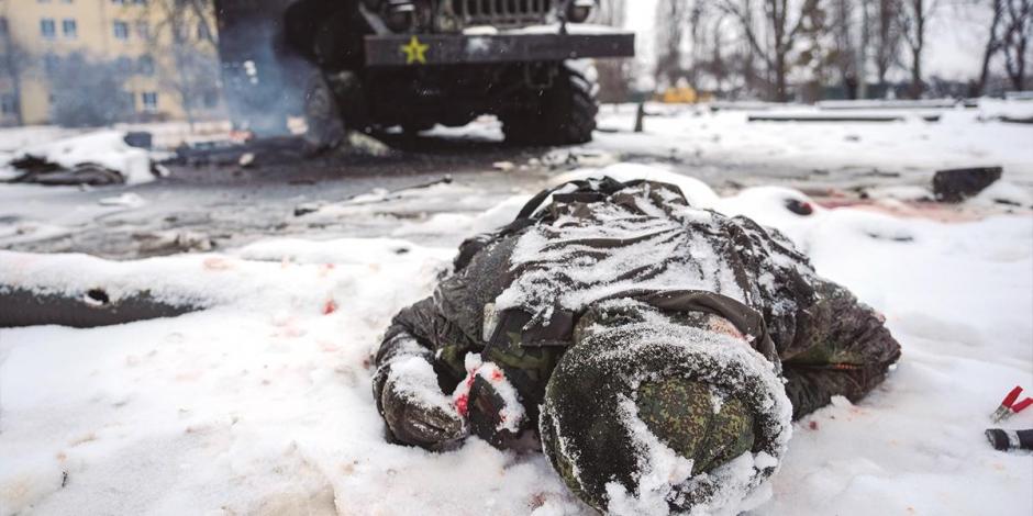 El cuerpo de un soldado ruso yace cubierto de nieve junto a un vehículo lanzacohetes ruso destruido, en las afueras de Járkov, Ucrania, ayer.