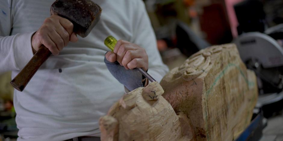 Un artesano elabora bocinas de madera para celular, en Veracruz, México.