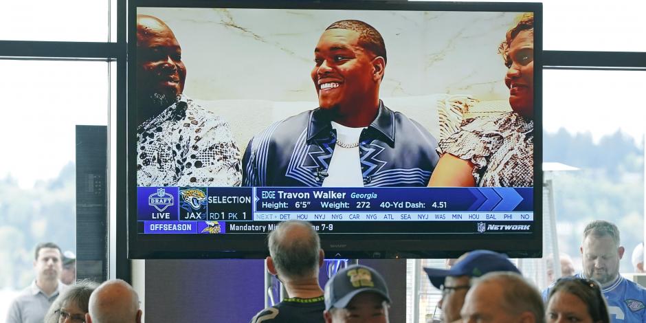 Aficionados de los Seahawks observan cómo Travon Walker, aparece en la televisión cuando los Jaguars lo eligieron como la primera selección en el NFL Draft 2022.