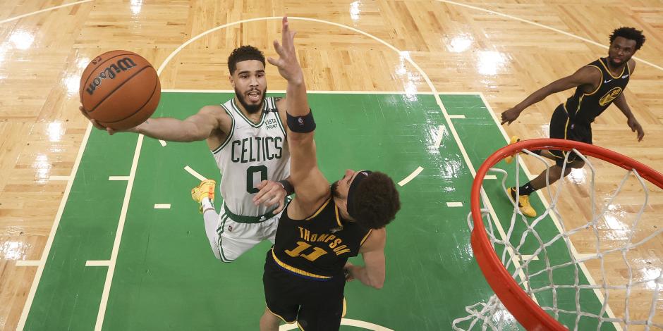 Jayson Tatum de los Celtics de Boston (0) salta para anotar contra Klay Thompson de los Warriors de Golden State (11) en el cuarto juego de las finales de la NBA en Boston.