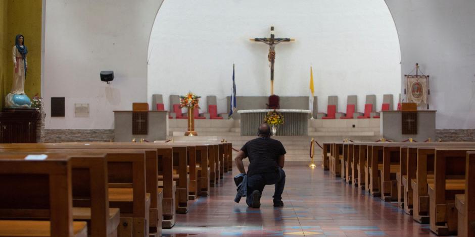 Un hombre se arrodilla en la Catedral Metropolitana cuando la policía nicaragüense prohibió una peregrinación católica en la capital, citando razones de seguridad interna, en Managua, Nicaragua.