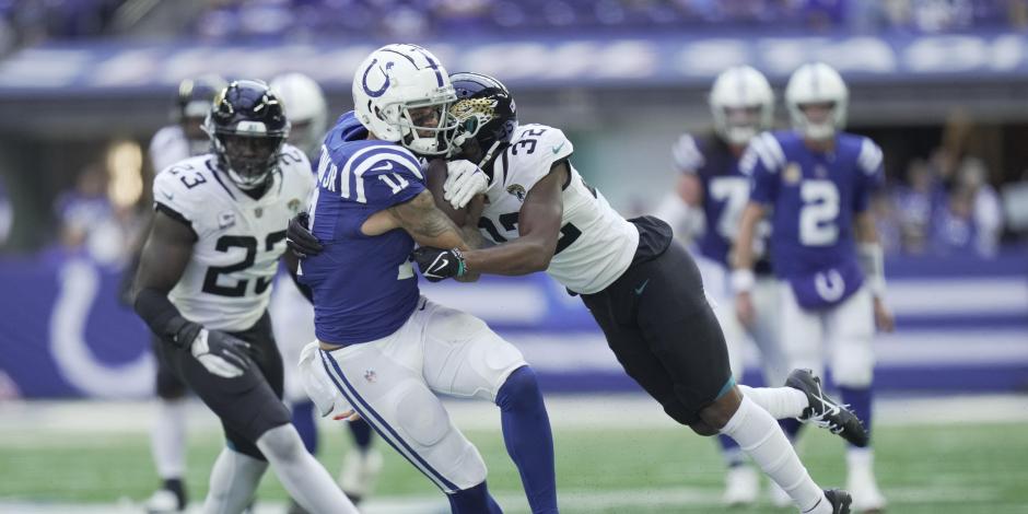 Michael Pittman Jr. (11), de los Indianapolis Colts, es tackleado por Foyesade Oluokun (23), de los Jacksonville Jaguars, en la Semana 6 de la NFL.