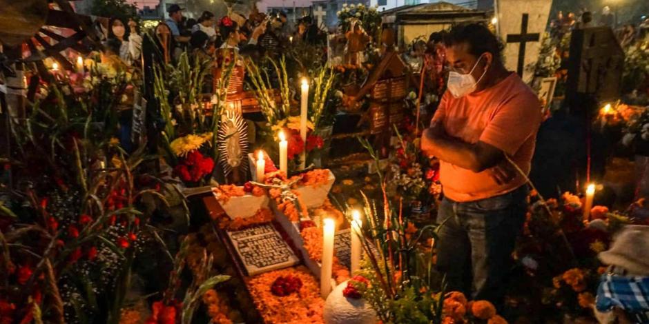 Familiares continúan conservando la tradicional velada en el panteón de Mixquic como parte de los festejos del Día de Muertos.