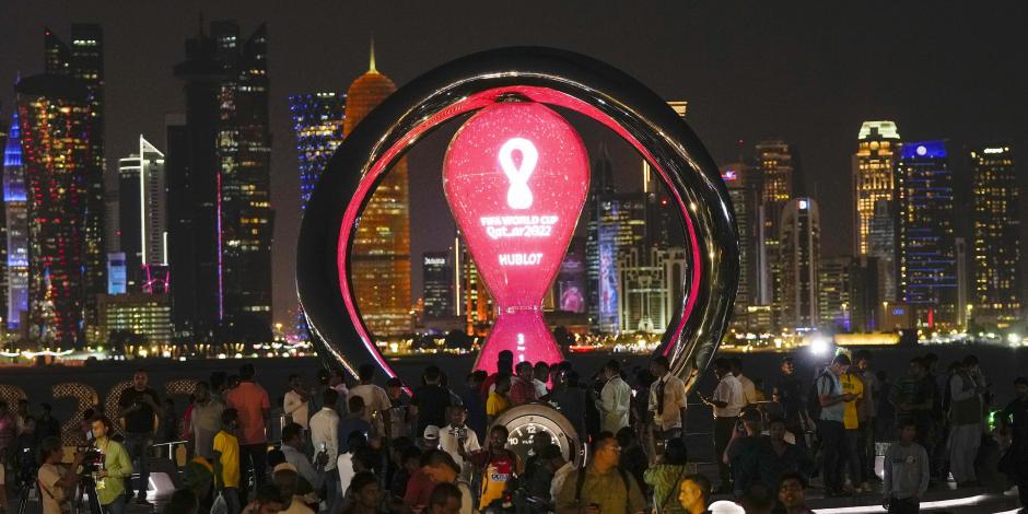 La gente se reúne alrededor del reloj de la cuenta regresiva oficial que muestra el tiempo restante para el inicio de la Copa del Mundo Qatar 2022, en Doha.