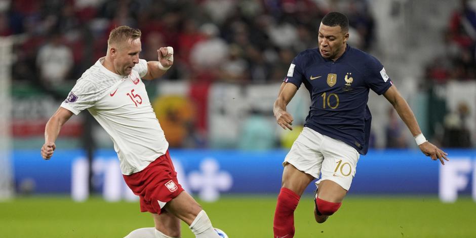 Kamil Glik y Kylian Mbappé pelean el balón en el Francia vs Polonia, octavos de final del Mundial Qatar 2022.