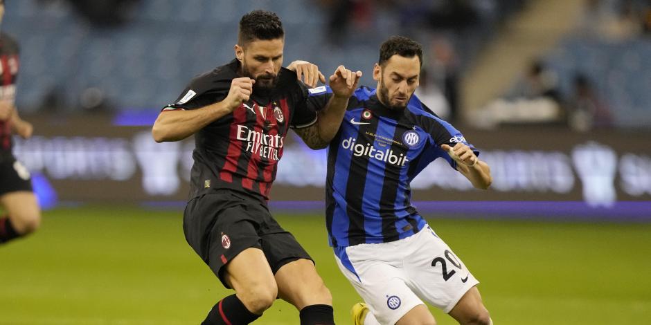 Olivier Giroud y Hakan Calhanoglu disputan el esférico durante el duelo de la Supercopa de Italia entre Milan e Inter de Milán.