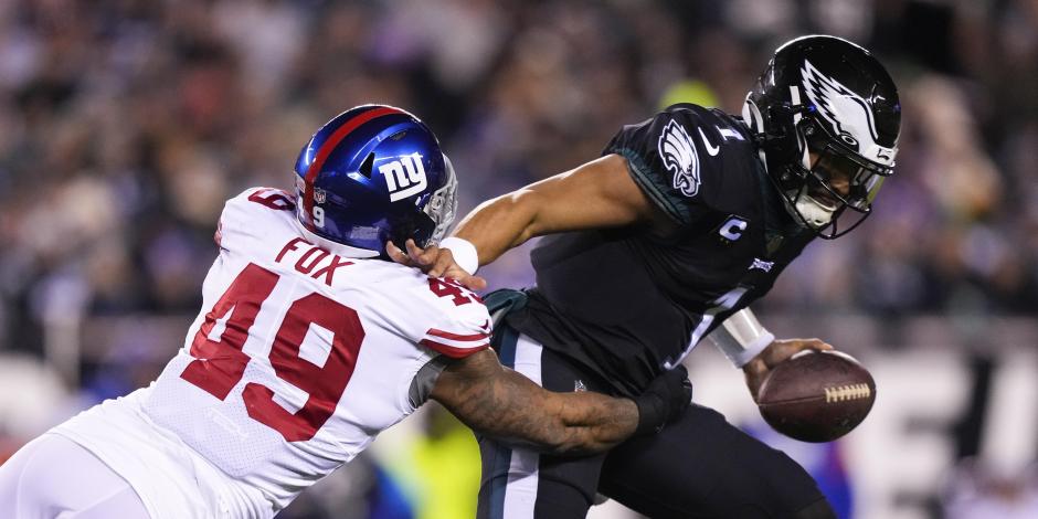 Jalen Hurts, derecha, quarterback de los Eagles, evita ser capturado por Tomon Fox, linebacker de los Giants de Nueva York