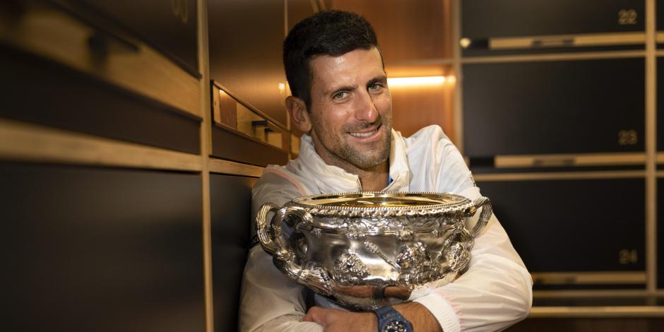 El serbio Novak Djokovic abraza la copa Norman Brookes Challenge en el vestidor después de derrotar a Stefanos Tsitsipas