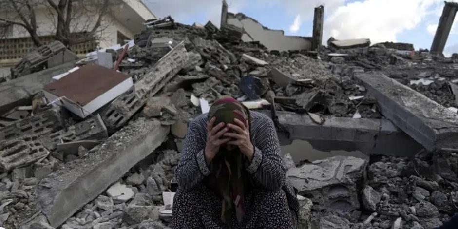 Una mujer sentada sobre los escombros de un edificio que se derrumbó por el sismo del lunes en Nurdagi, sur de Turquía, el martes 7 de febrero de 2023.