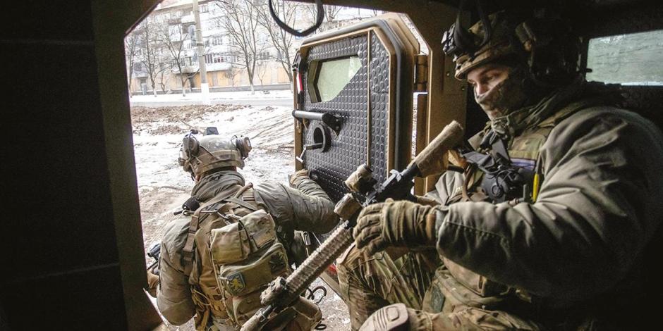 Militares ucranianos abandonan un vehículo blindado de transporte de personal, en la ciudad de primera línea de Bakhmut, en la región de Donetsk, ayer.