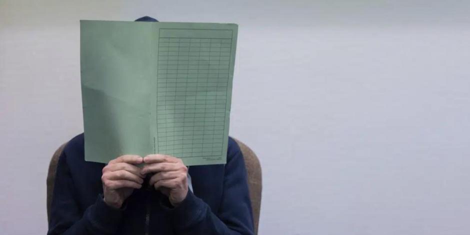 Un hombre acusado de abuso sexual de menores se cubre la cara en el tribunal en Colonia, Alemania, el 28 de febrero de 2023.