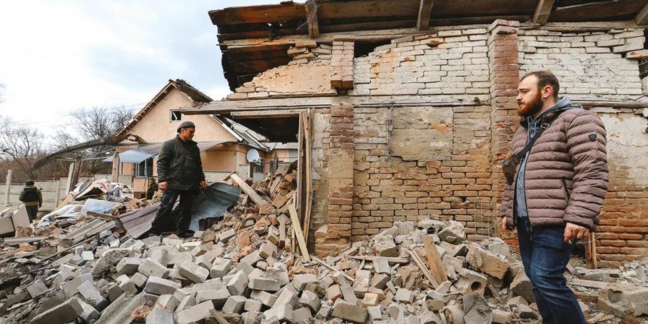 Ciudadanos evalúan los daños en inmuebles alcanzados por los ataques rusos en Donbás, ayer.