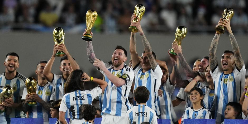 Lionel Messi y otros futbolistas de Argentina sostienen réplicas de la Copa Mundial de la FIFA que conquistaron en Qatar, después de su triunfo ante Panamá en Buenos Aires.