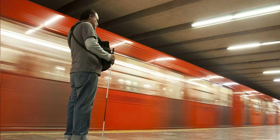 Una  persona espera en el andén para subir al Metro