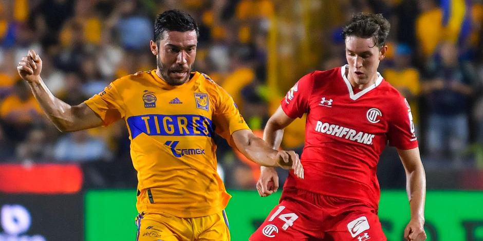 Juan Pablo Vigón da un pase ante la marca de Marcel Ruiz en el partido entre Tigres y Toluca.