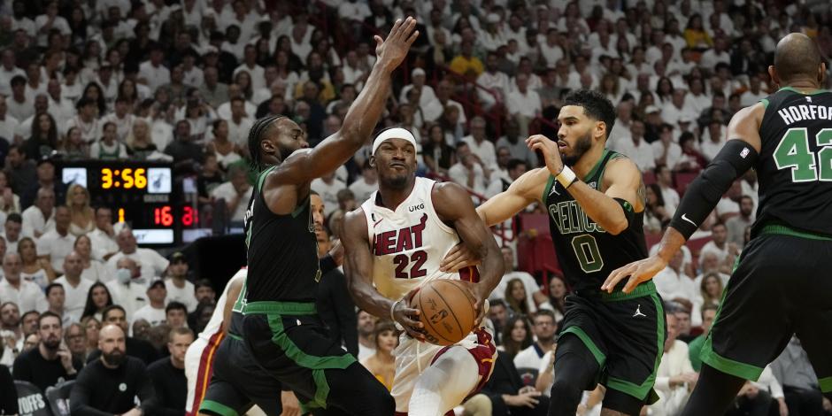 El alero de los Boston Celtics Jayson Tatum (0) y el guardia Jaylen Brown (7) defienden al alero del Miami Heat Jimmy Butler (22) durante el Juego 3 de las finales de la Conferencia Este de la NBA