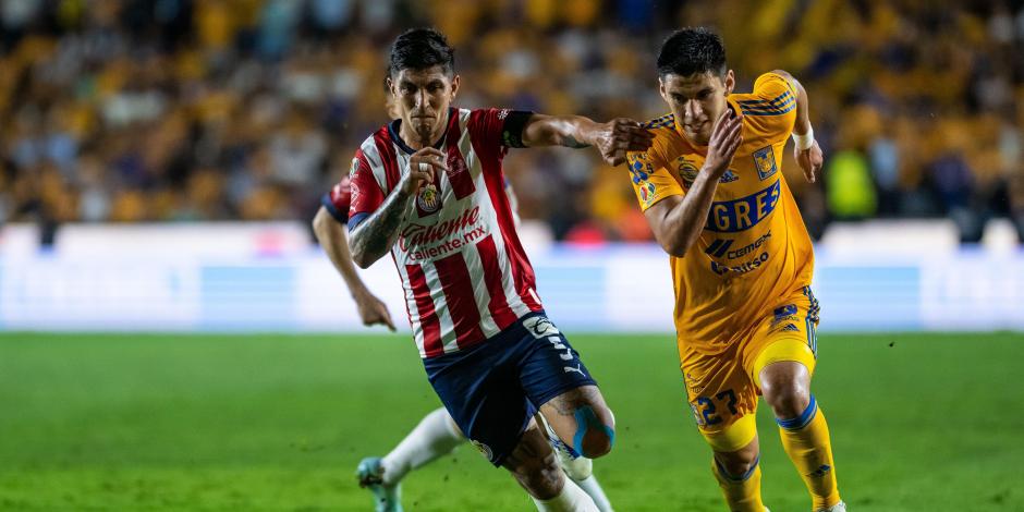 Víctor Guzmán y Jesús Angulo disputan un balón en la ida de la final del Clausura 2023 entre Chivas y Tigres.