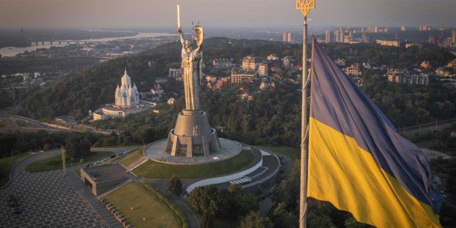 La bandera ucraniana ondea mientras trabajadores instalan el escudo del país en la estatua más alta del país, la estatua de la Madre Ucrania, luego de que retiraron el martillo y la hoz soviéticos, el domingo 6 de agosto de 2023, en Kiev