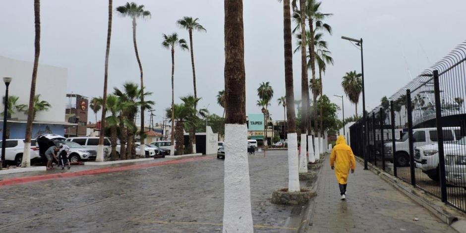 Un hombre camina bajo la lluvia mientras el huracán Hilary, de categoría 4, se precipita hacia la península mexicana de Baja California, en Cabo San Lucas, México, el 18 de agosto de 2023.
