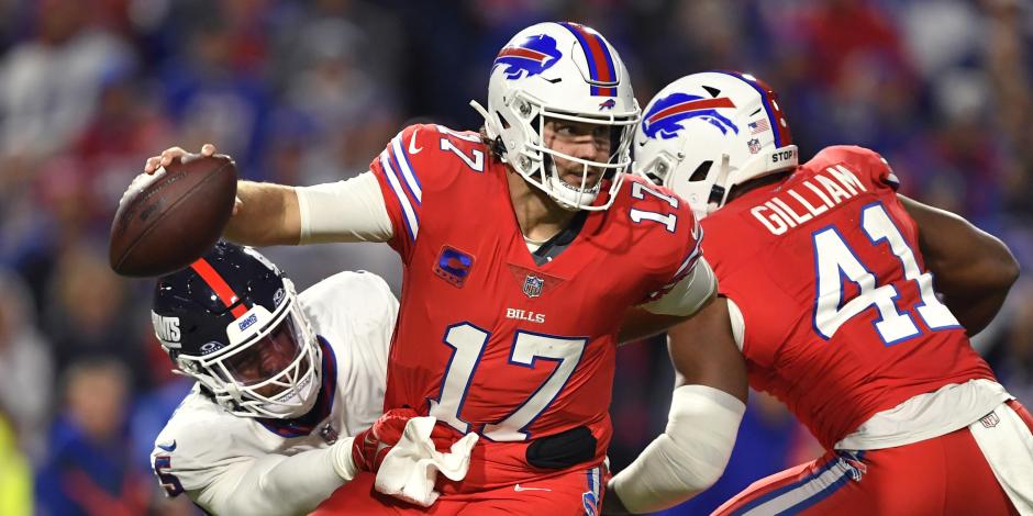 El quarterback Josh Allen (17), de los Bills de Buffalo, trata de evadir la tacleada del linebacker Kayvon Thibodeaux, izquierda, de los Giants de Nueva York