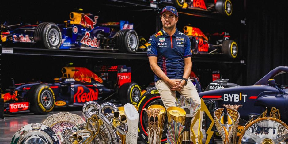 Checo Pérez posa con los trofeos ganados por Red Bull en la temporada 2023 de la F1.