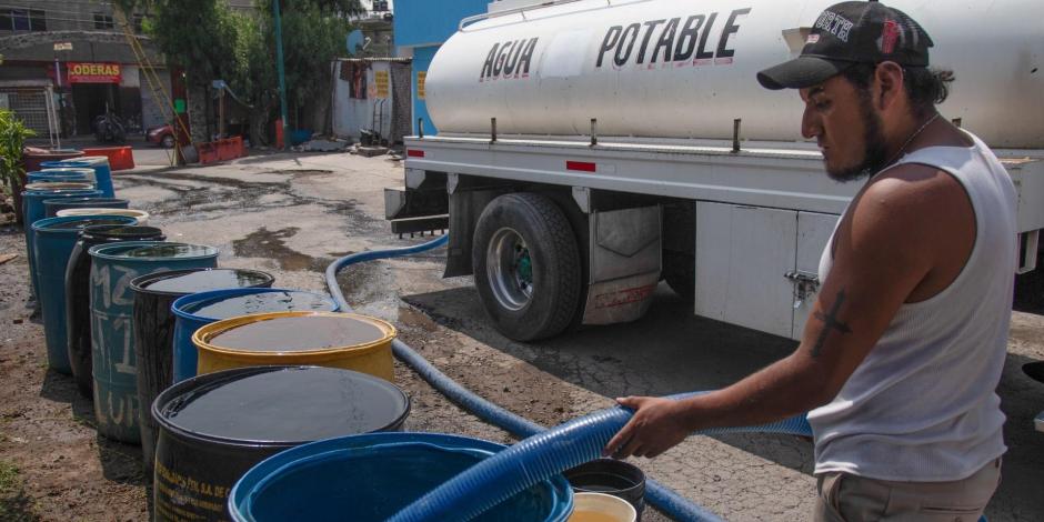 Un trabajador de una pipa de agua suministró botes de habitantes de la Unidad Habitacional Minas Polvorilla Acapatzingo, alcaldía Iztapalapa