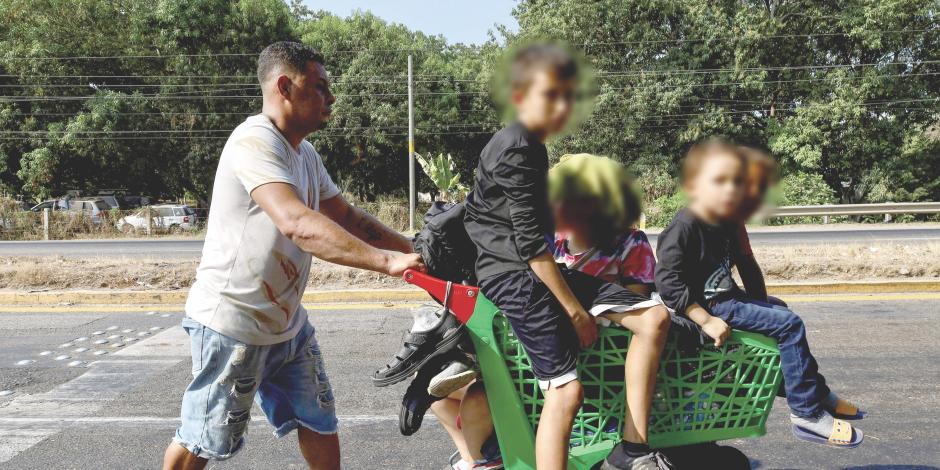 Un migrante hondureño lleva a sus hijos en un carrito, ayer, en Chiapas.