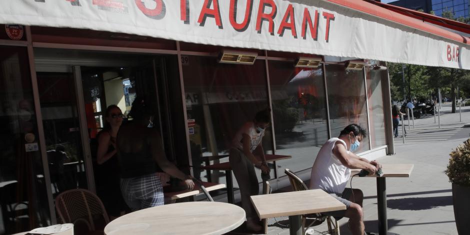 Personas preparan la terraza de su restaurante en Boulogne-Billancourt, a las afueras de París, el 28 de mayo de 2020.
