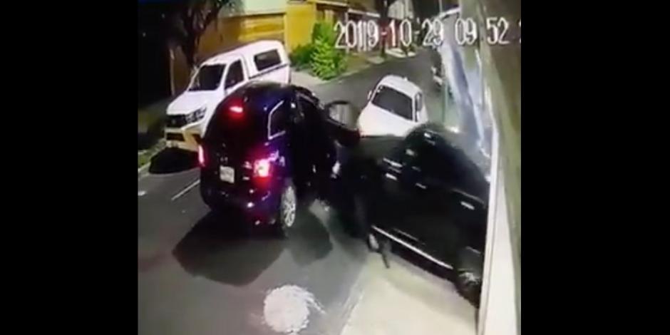 Entran a cochera para robarle auto, pero los arrolla y escapa (VIDEO)
