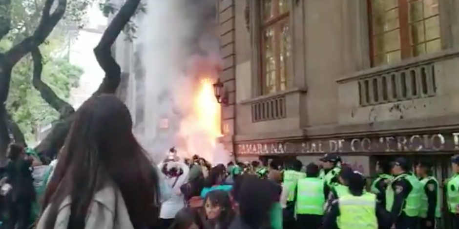 VIDEO: Encapuchadas prenden fuego a puerta de la Cámara de Comercio