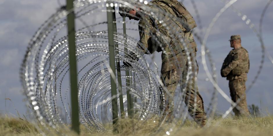 Colocan militares de EU alambre de púas en valla metálica en Nogales