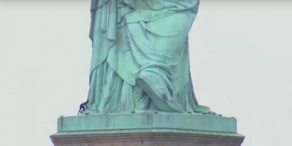 Mujer escala Estatua de la Libertad en protesta contra política migratoria