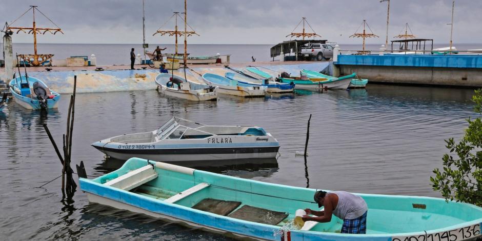 Pescadores ribereños de la bahía de Campeche toman sus precauciones con sus embarcaciones, las cuales ya sufren estragos por el paso de la tormenta tropical Cristóbal, el 2 de junio de 2020.