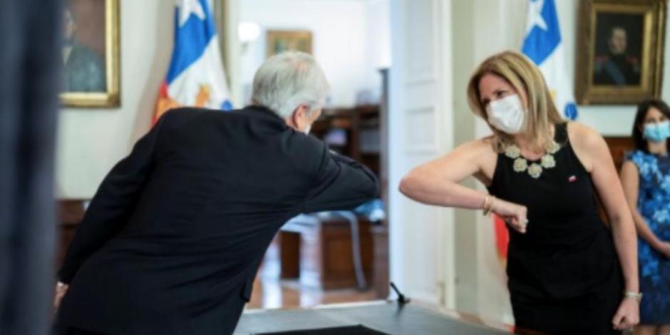 El presidente chileno Sebastián Piñera choca los codos a modo de saludo con la entonces recién nombrada ministra de la Mujer, Macarena Santelices, el 6 de mayo de 2020.