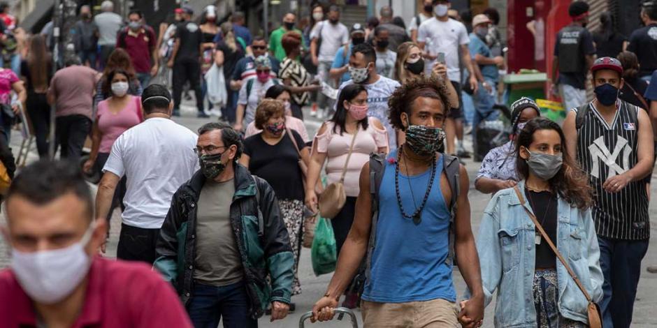 Brasileños caminan por una transitada avenida en la ciudad de Sao Paulo, una de las más golpeadas por el virus, ayer.