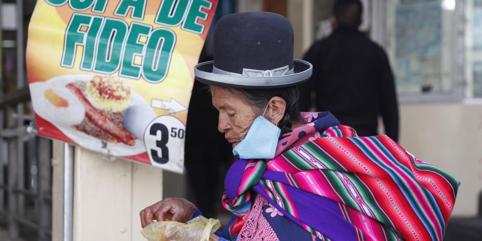 Una mujer come una sopa de fideos en La Paz, Bolivia, 2 de junio de 2020.