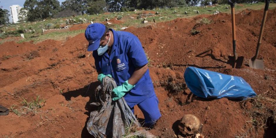 Un trabajador exhuma el cuerpo de una persona enterrada hace tres años en el cementerio de Vila Formosa.