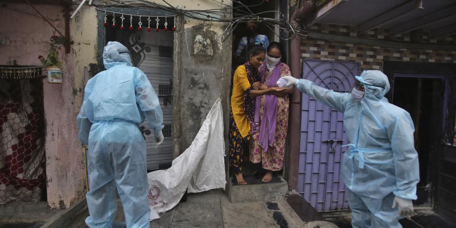 Un trabajador de la salud le da desinfectante de manos a una niña durante un campamento de control en un barrio pobre en Mumbai, India, el 17 de junio de 2020.