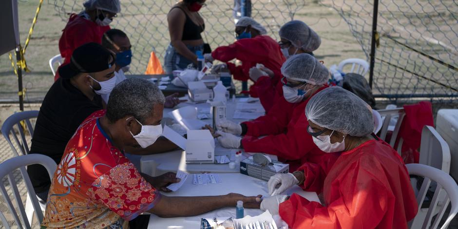 Una trabajadora de la salud aplica una prueba a un hombre para detectar COVID-19, el 8 de junio de 2020, en Duque de Caxias, Brasil.