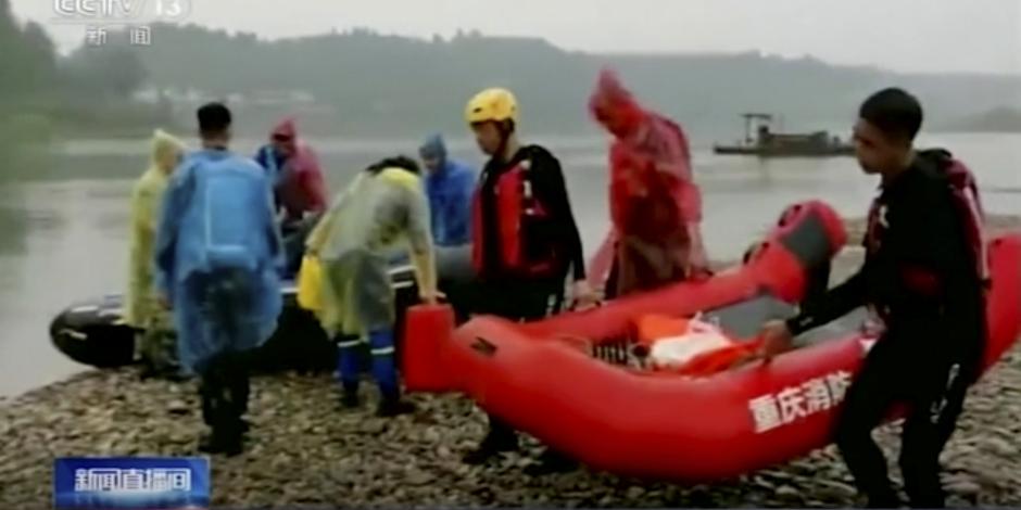 En esta imagen del 22 de junio de 2020, tomada de un video de la cadena estatal china CCTV, rescatistas trabajando en la orilla de un río en la provincia suroccidental de Chongqing.