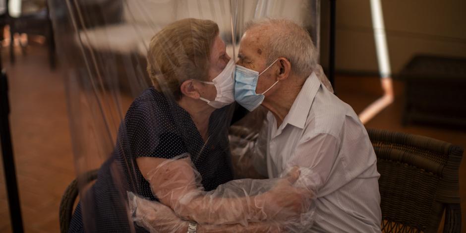 Dos personas se abrazan a través de una cortina de plástico para evitar contraer el virus en un hogar de ancianos en Barcelona, ​​España, ayer.