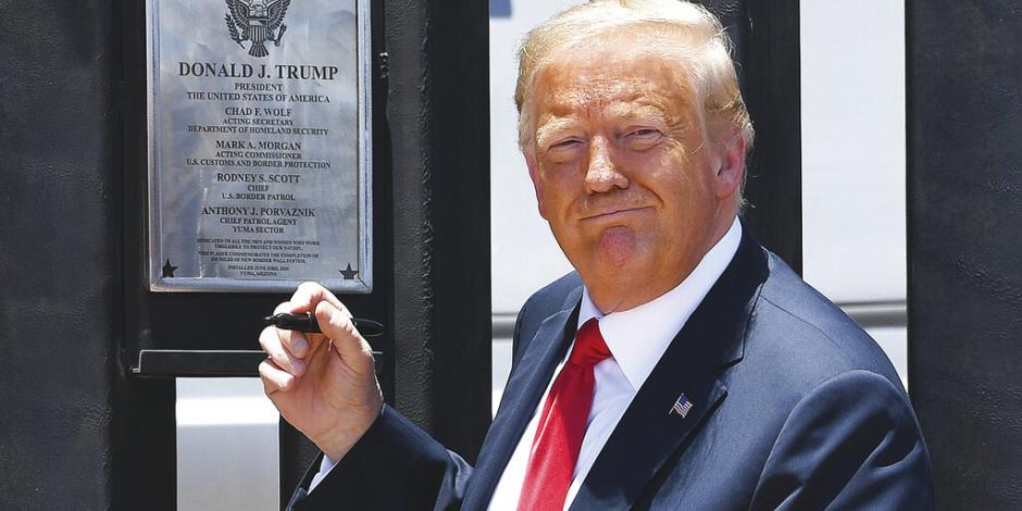 Con un bolígrafo negro, autografió una placa que conmemoró la construcción de 200 millas (poco más de 321 kilómetros) del muro fronterizo.