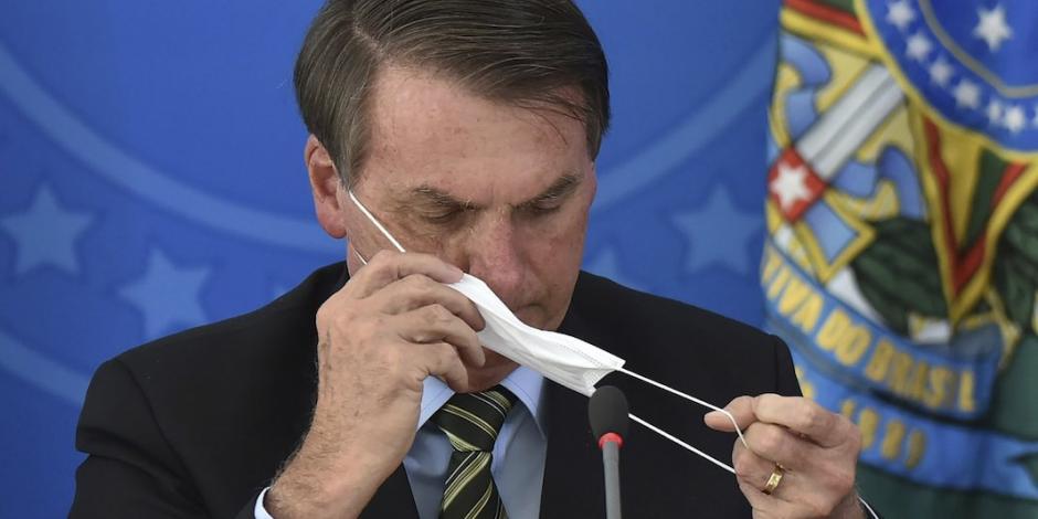 El mandatario brasileño se retira el cubreboca para hablar, en abril.