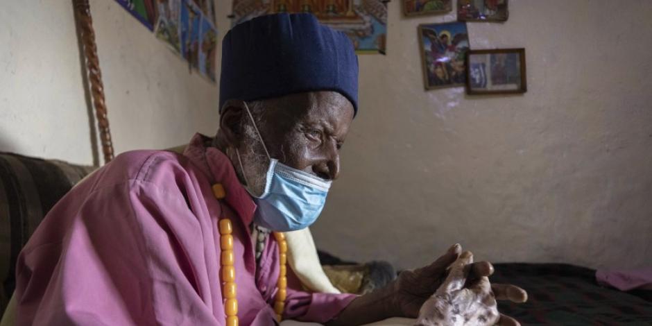 El centenario Tilahun Woldemichael llora y reza después de pasar semanas en un hospital recuperándose del coronavirus, en su casa en Adis Abeba, Etiopía, sábado 27 de junio de 2020. Su familia dice que tiene 114 años.